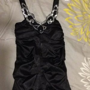 Black dress with sequins and black stones .
